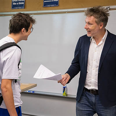 A philosophy professor talks with a student after class.