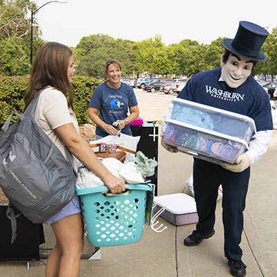 Mr. Ichabod helps a student carry their belongings to their new home.