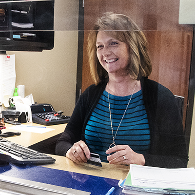 A Washburn Business Office employee smiles while helping someone.