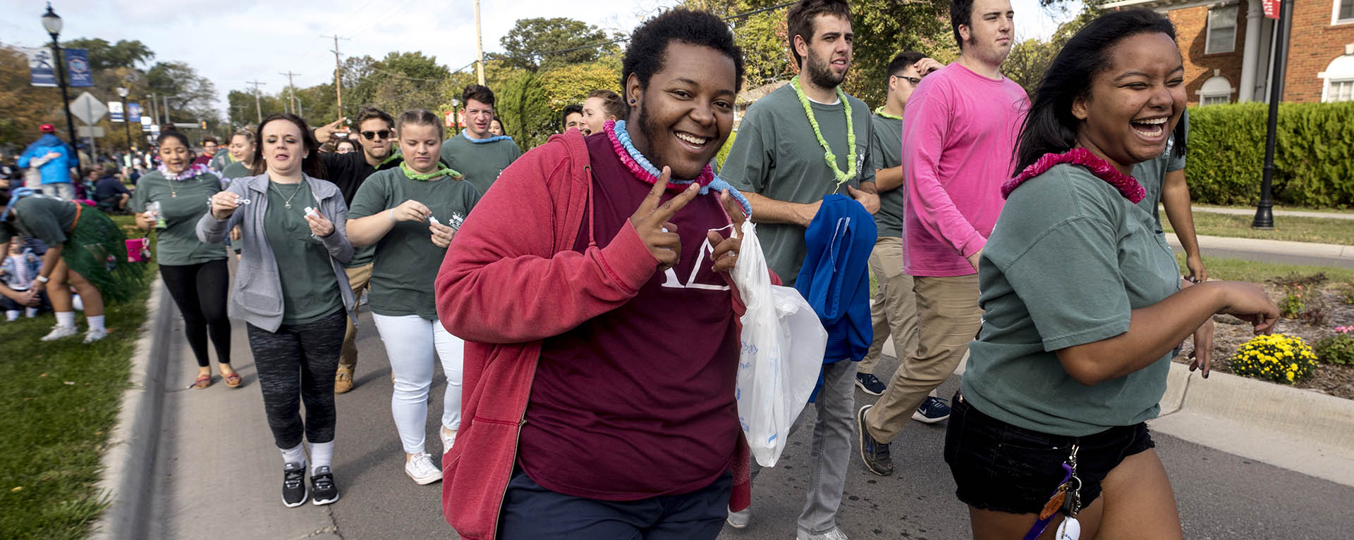 A student smiles while walking in the homecoming parade.