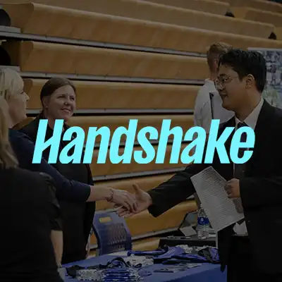 employer shaking hands with student at career fair with Handshake logo overlay