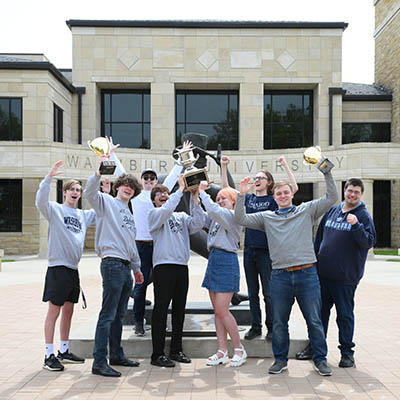Students celebrate their championship by lifting the trophy in front of Morgan Hall.