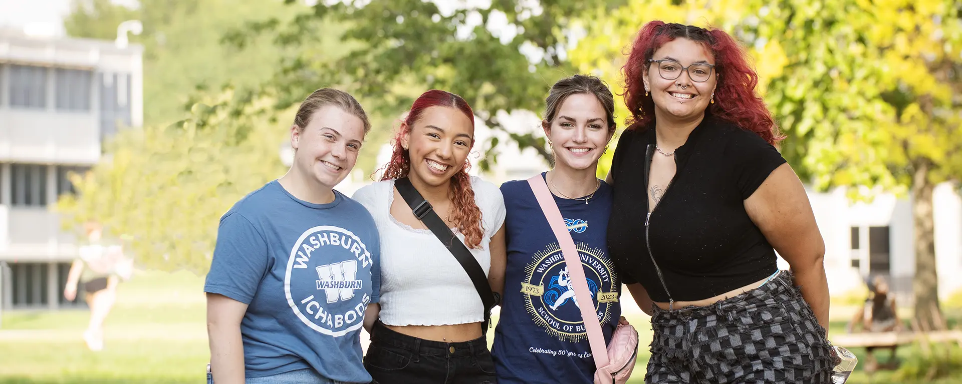 students smiling, standing on campus