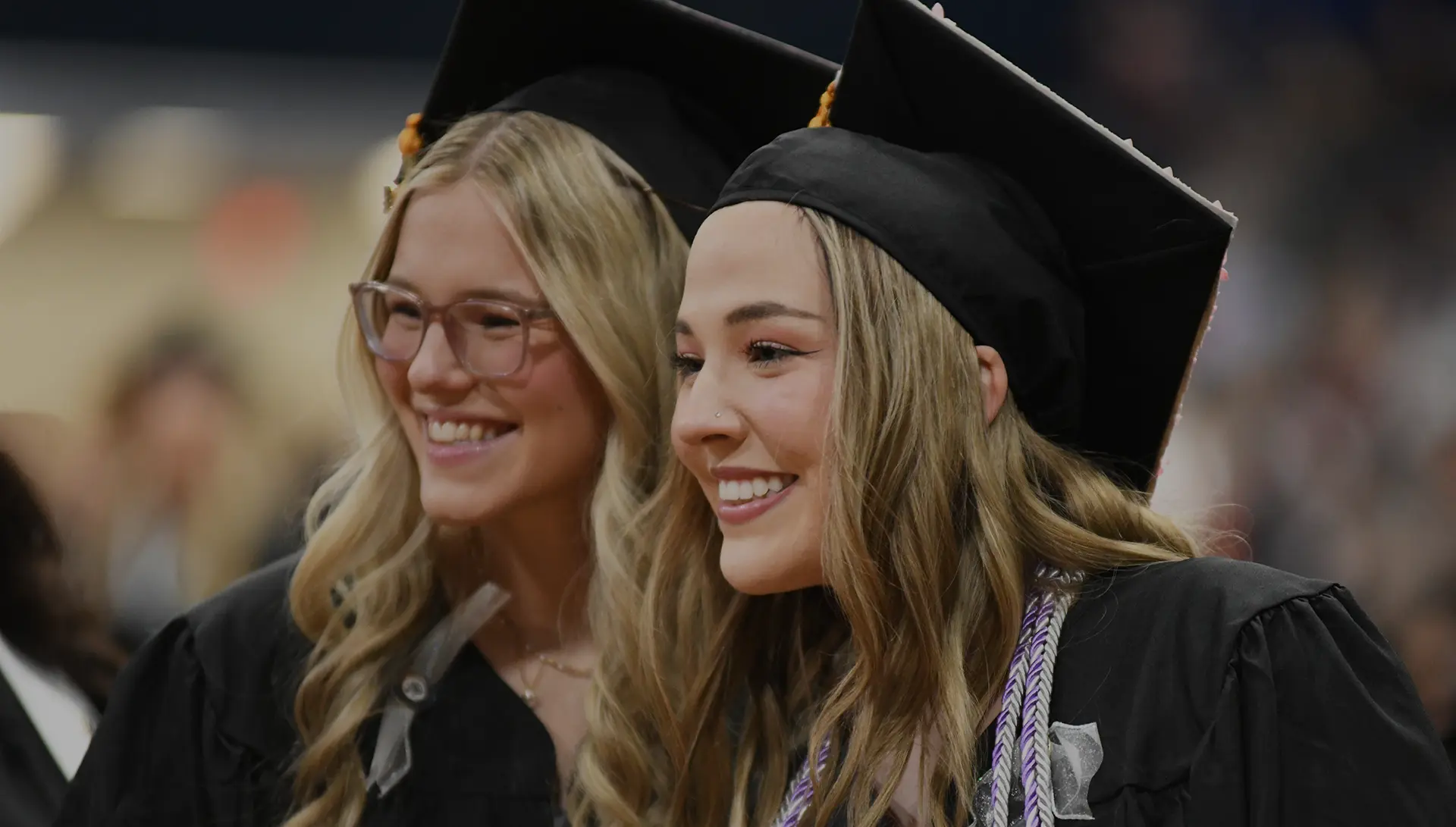 Graduates smile at commencement.