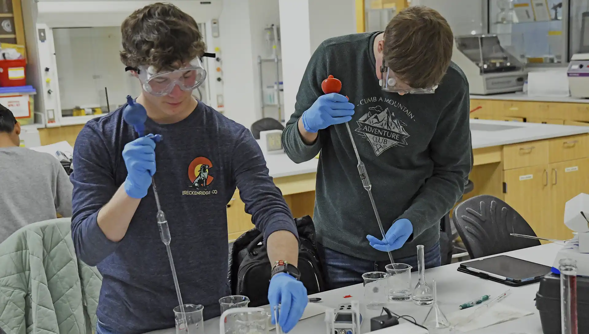 two students perform experiment in chemistry