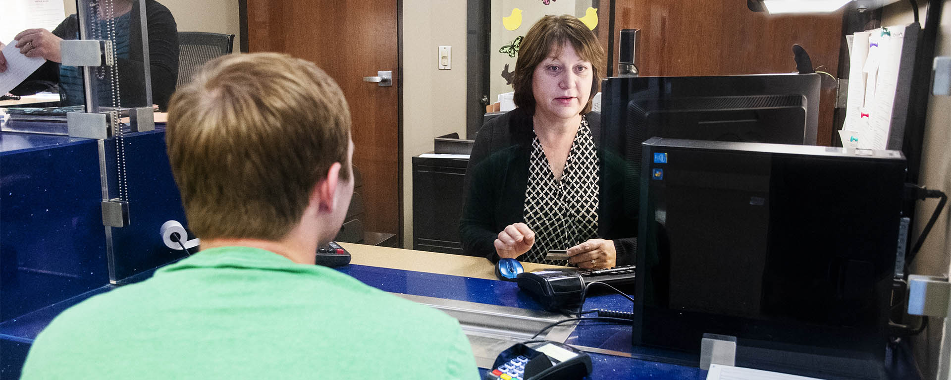 A Washburn Business Office employee helps a student in Morgan Hall.