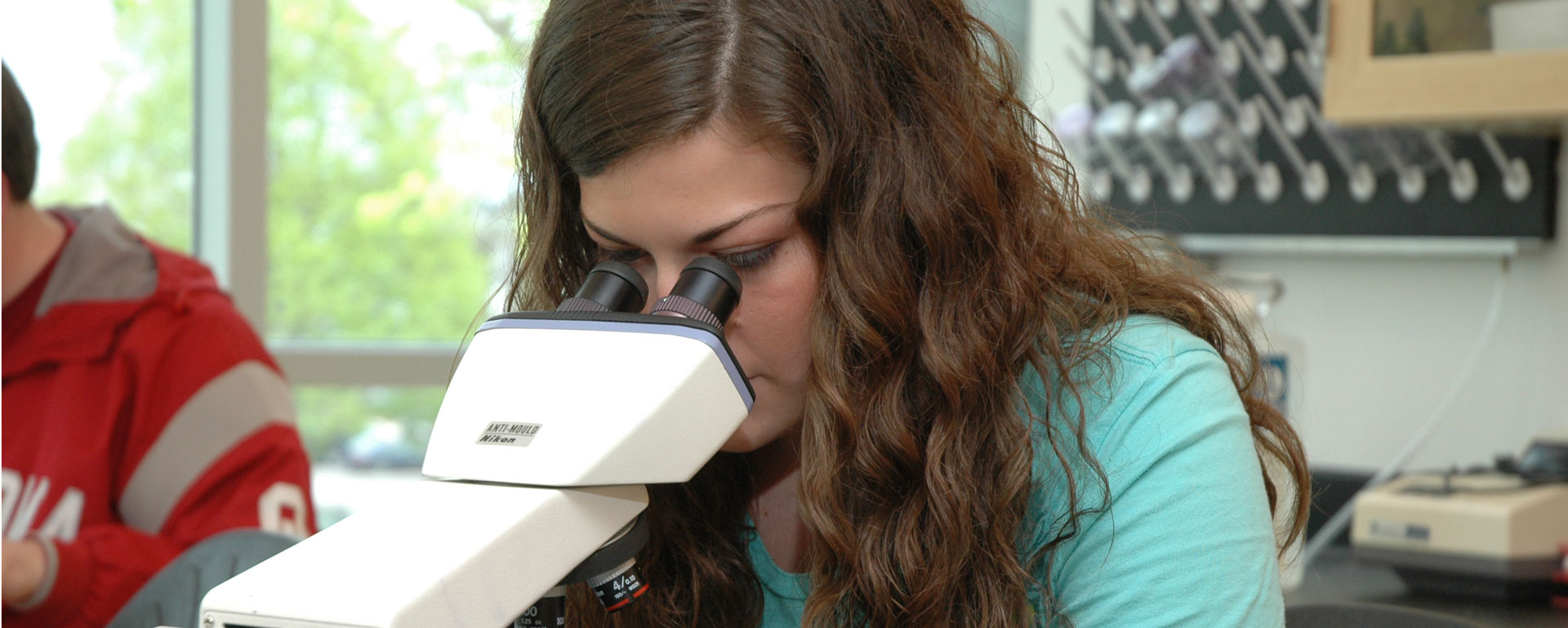 student using a microscope