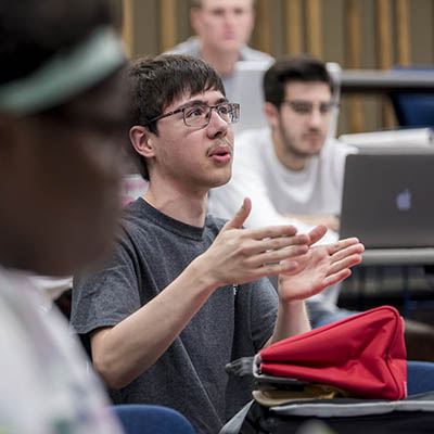 A student gestures while talking in class.