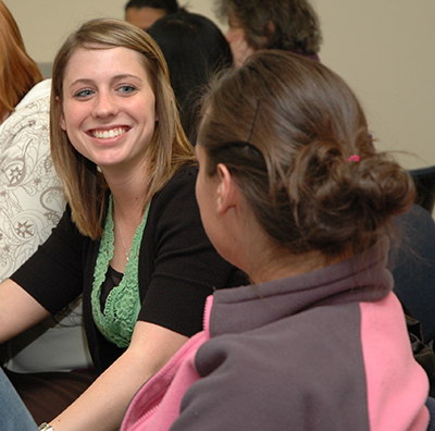 A Washburn student smiles while chatting with a classmate during a School of Nursing class.