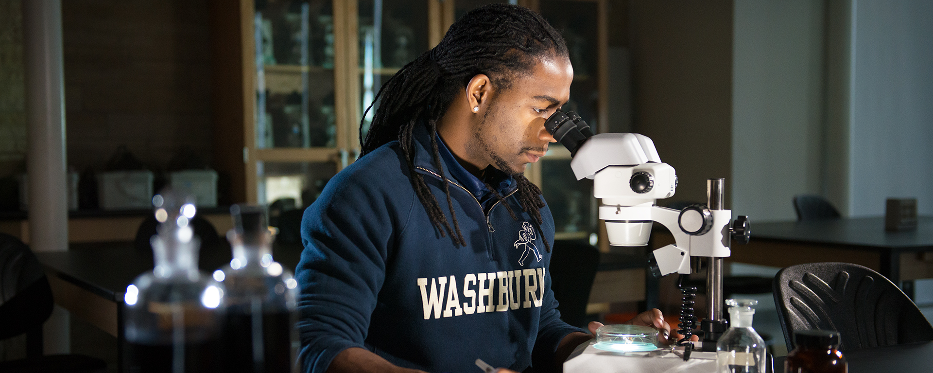 A Washburn student uses a microscope in a classroom at Stoffer Science Hall.