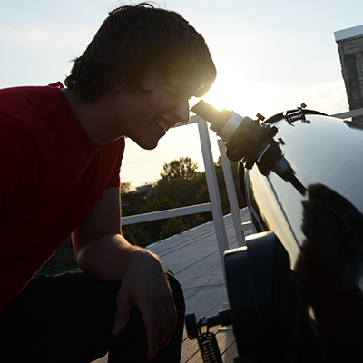 Student looking through telescope