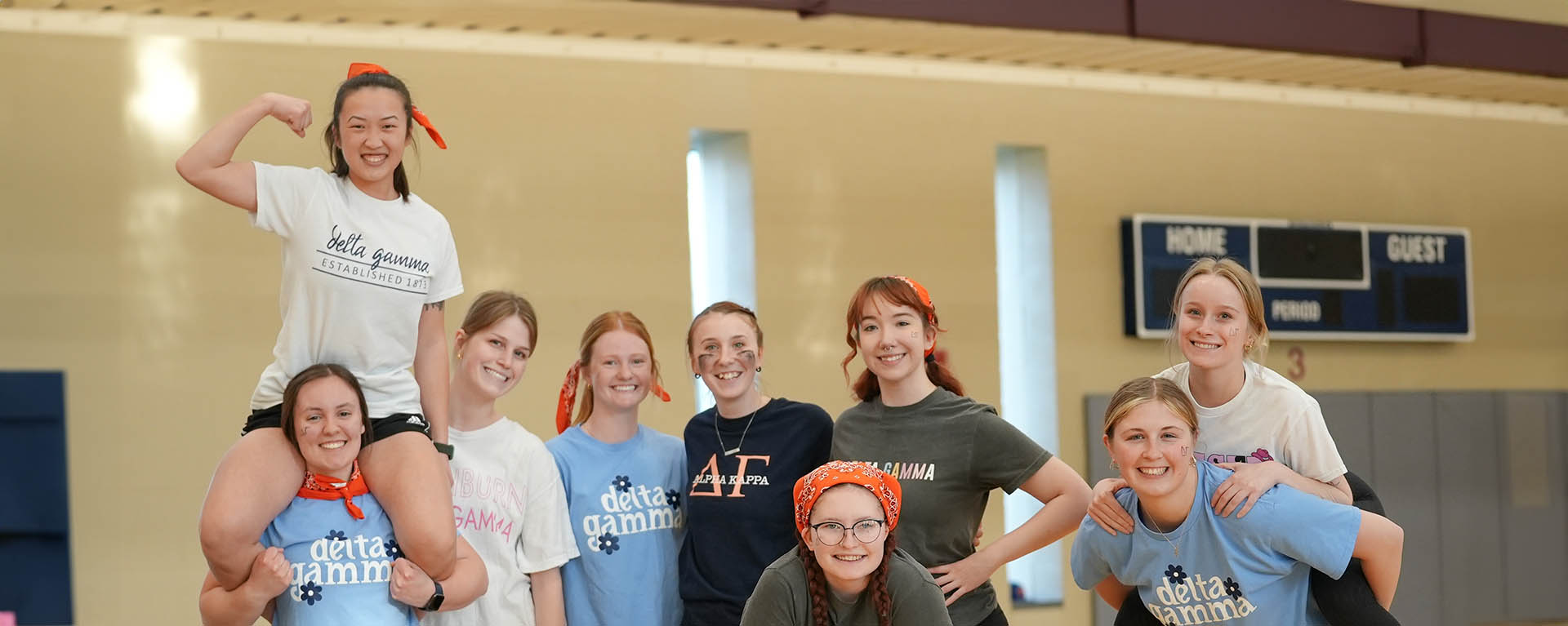 A group of sorority members smiles and pose for a photo at the greek olympics event.