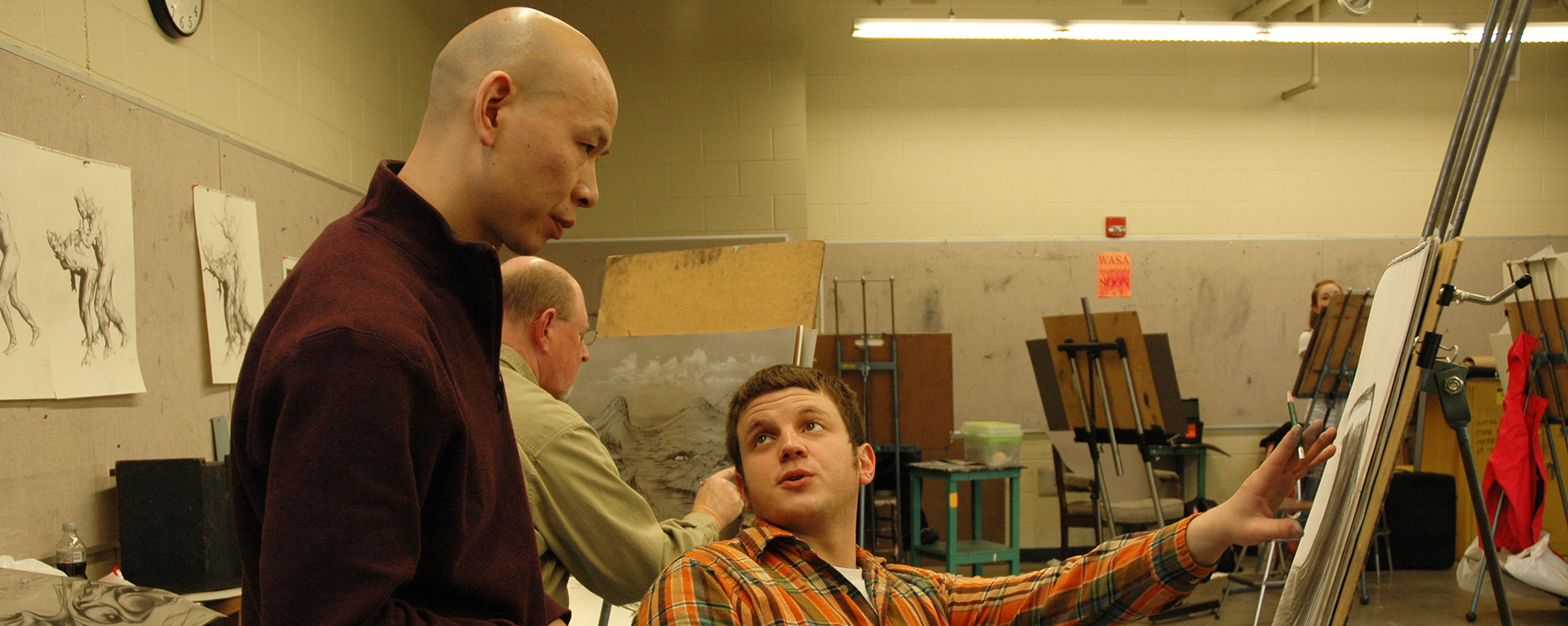 A Washburn professor works with a student during an art class.