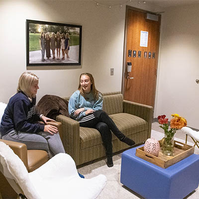 Students smile and chat in the living area of their suite.