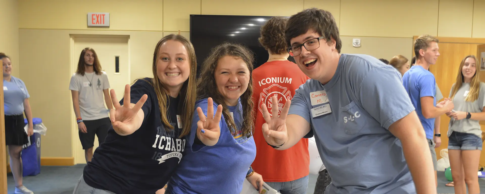 Three leadership students smile while at a fun event.