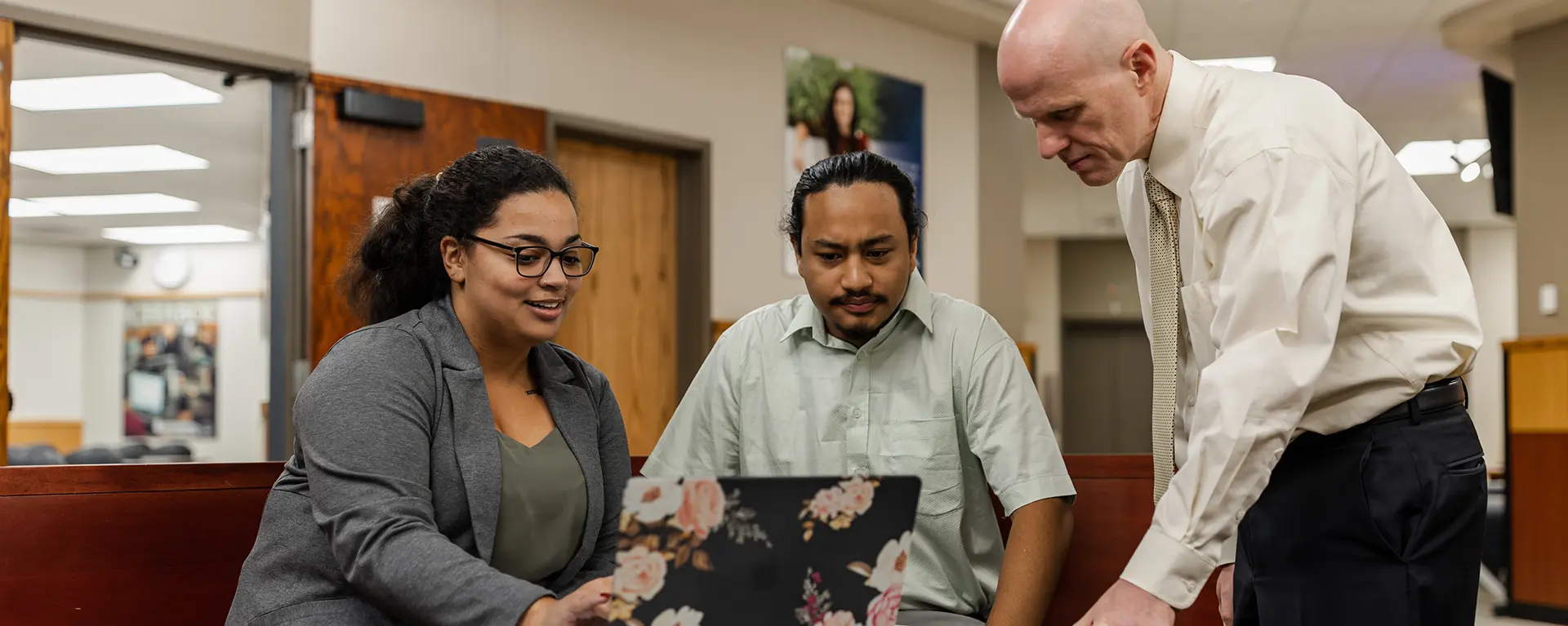 A business professor helps two students study.