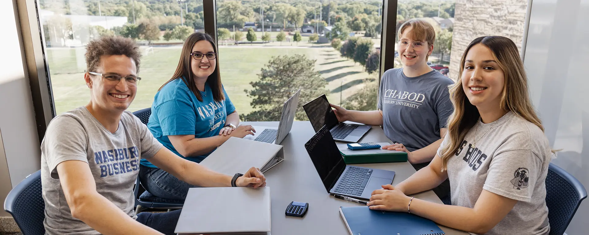 Business students smile while studying together.