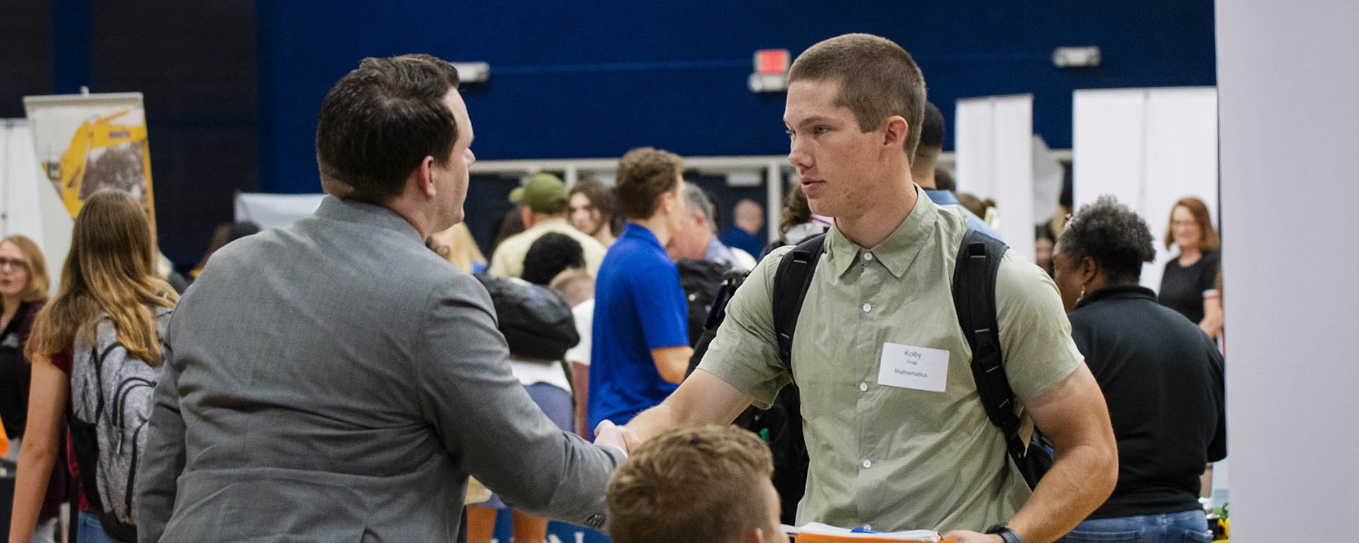 A student shakes hands with a potential employer.