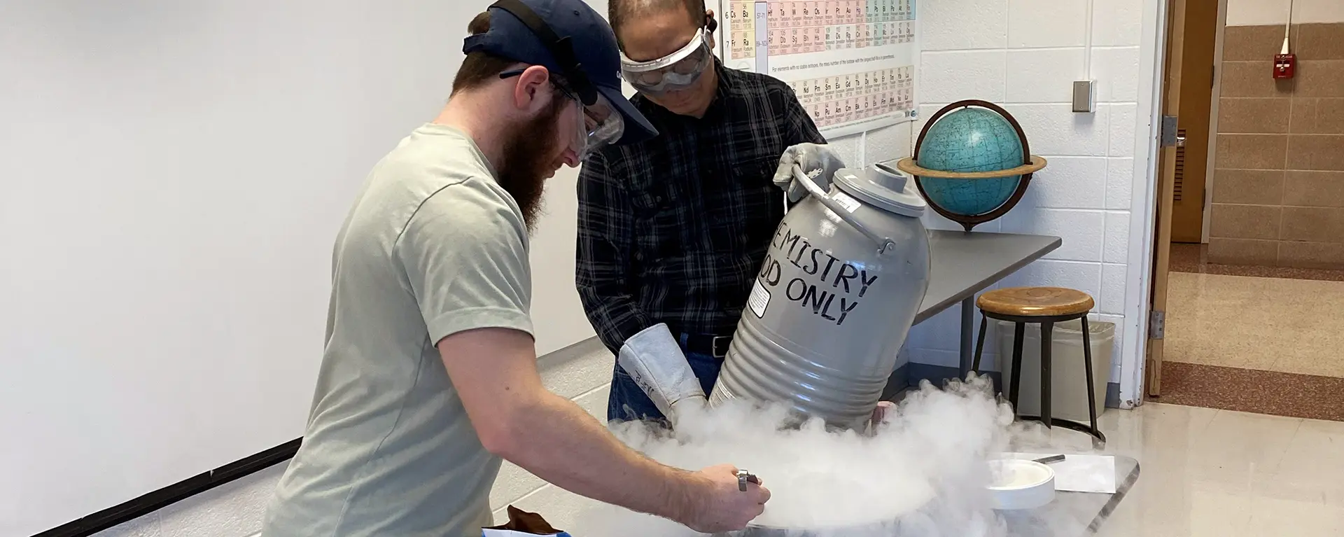 A chemistry club member and professor do an experiment with dry ice.