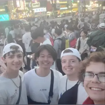 Four students pose for a photo amongst a crowd while studying abroad in Japan.