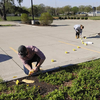 Students examine a mock crime scene in a parking lot.