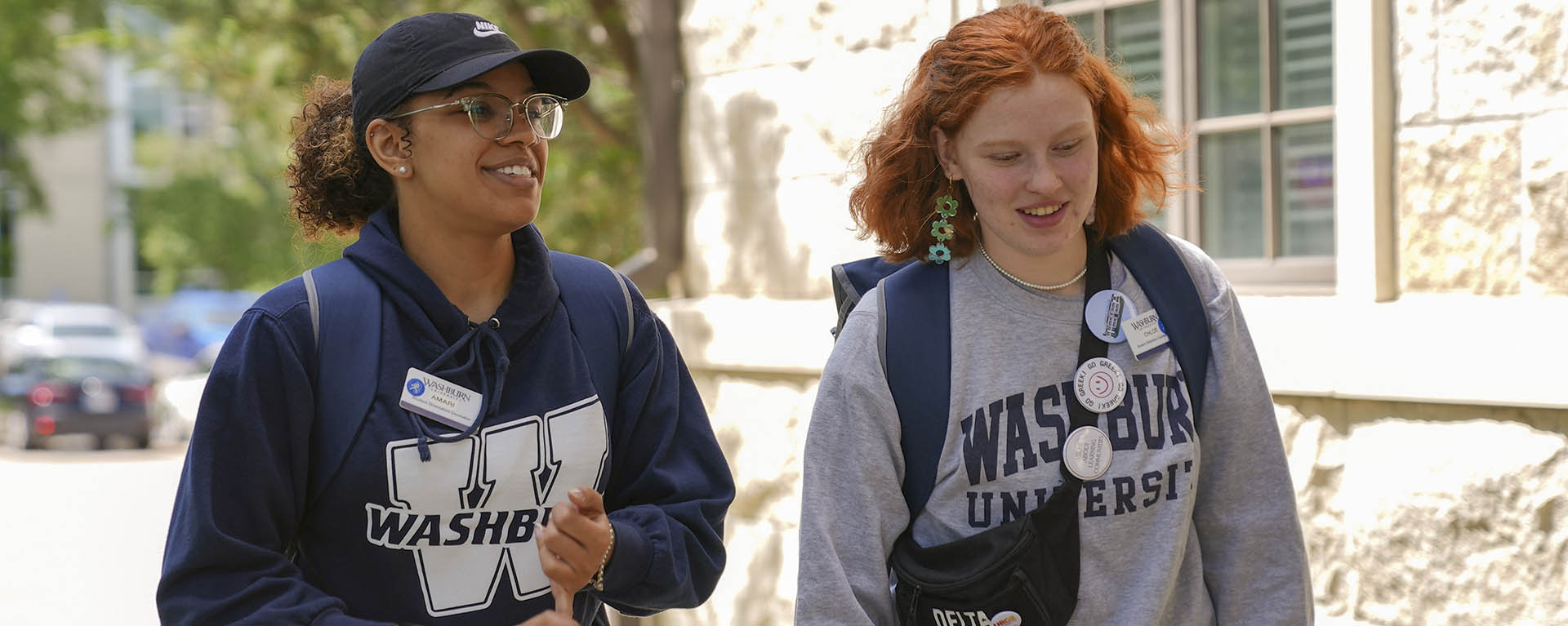 Students chat while walking on campus.