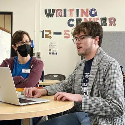 Two students work on an essay in the writing center.