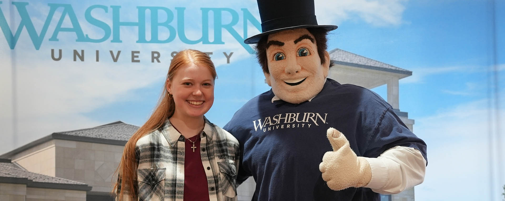 Mr. Ichabod mascot smiles while posing with a student.